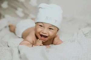 laughing baby white cap